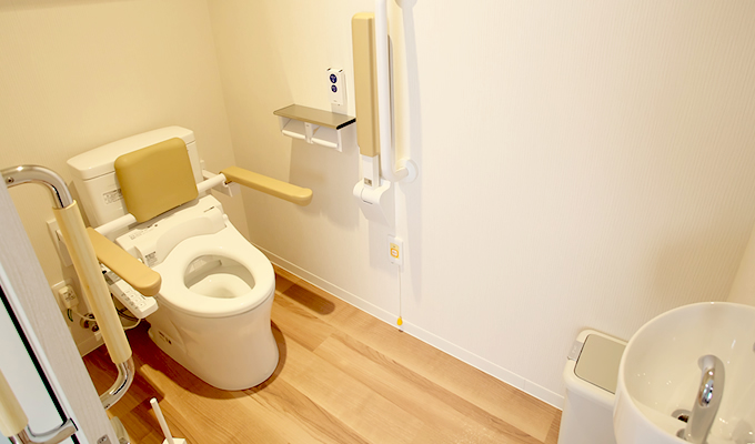 トイレには折り畳みできるサポート器具が装着され、立ったり座ったりを支援。