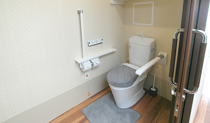 温水洗浄機能付き便座のトイレです。手すりは可動式になっています。